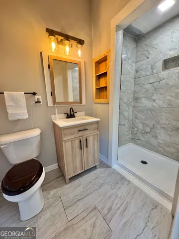 a bathroom with a sink a toilet and shower
