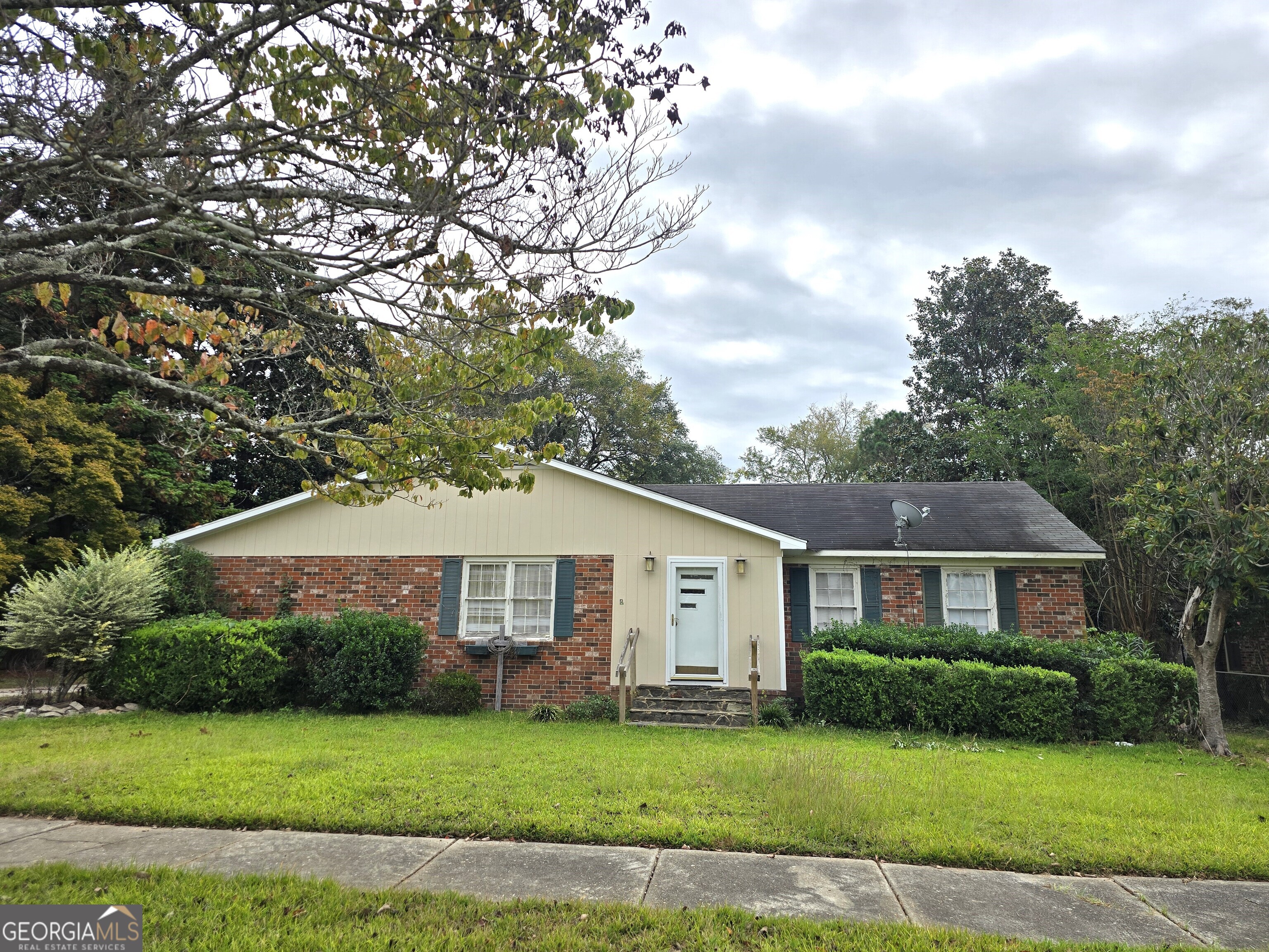 716 Screven Street Louisville, GA 30434 - Photo 1 of 12 a front view of a house with a garden and yard