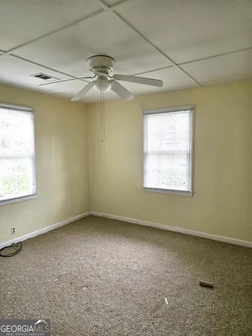 an empty room with a window and a fan