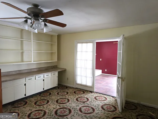 a room with chandelier fan and wooden floor