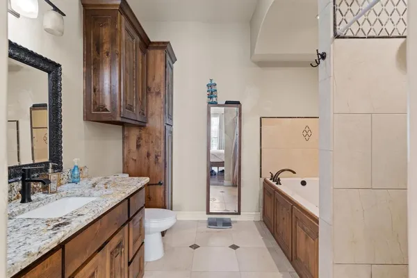 a bathroom with a granite countertop sink a toilet and shower
