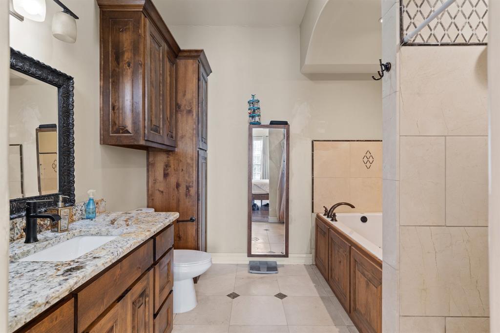 3993 Seaborn Road Ponder, TX 76259 - Photo 14 of 26 a bathroom with a granite countertop sink a toilet and shower