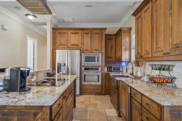 a kitchen with stainless steel appliances granite countertop a stove top oven a sink and dishwasher