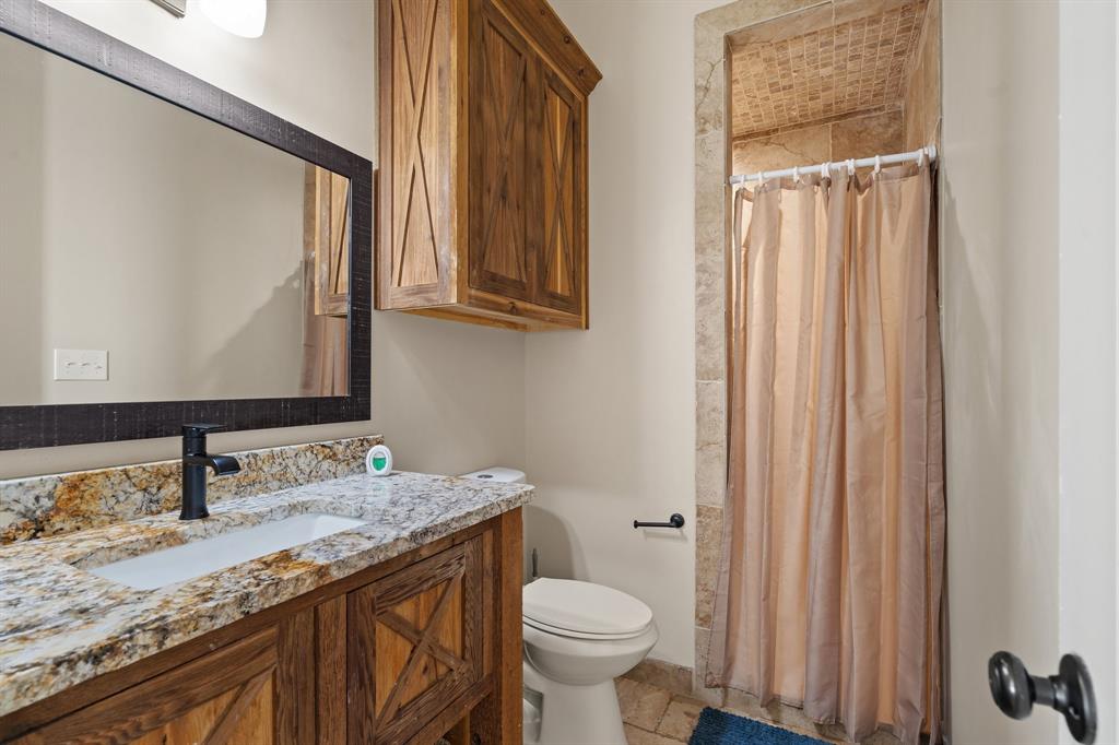 3993 Seaborn Road Ponder, TX 76259 - Photo 9 of 26 a bathroom with a granite countertop sink toilet and mirror