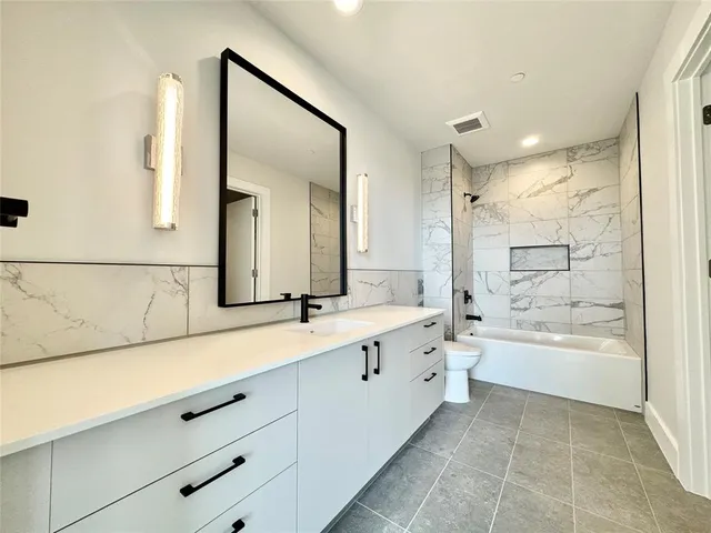 a bathroom with a bathtub sink and mirror