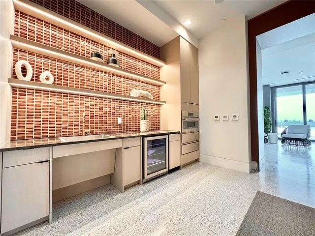 a living room with stainless steel appliances granite countertop a sink and dishwasher with wooden floor