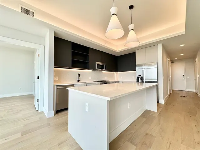 a large kitchen with a large counter top appliances and cabinets