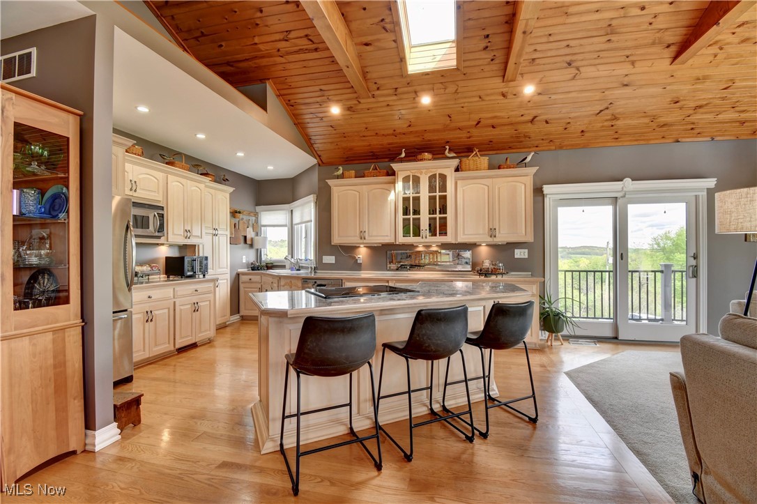 85530 Beagle Club Road Scio, OH 43988 - Photo 14 of 49 Kitchen featuring appliances with stainless steel finishes, wooden ceiling with exposed beams, a kitchen breakfast bar, glass insert cabinets, and light wood finished floors