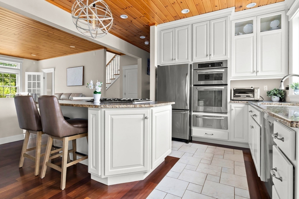 24 Old Rowley Road Newbury, MA 01951 - Photo 4 of 42 a kitchen with granite countertop a stove chairs and refrigerator