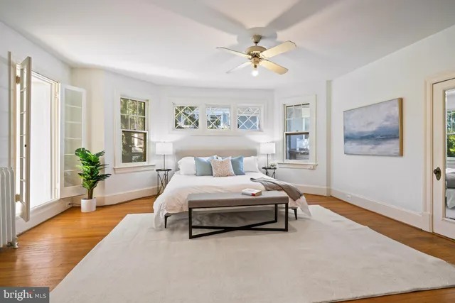 a spacious bedroom with a bed painting on wall and a potted plant