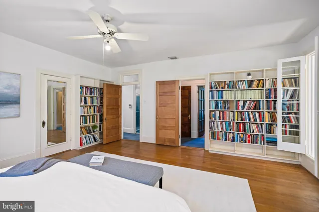 a living room with stainless steel furniture hardwood floor and a ceiling fan
