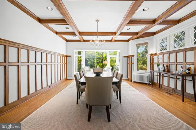 a dining room with furniture a chandelier and wooden floor