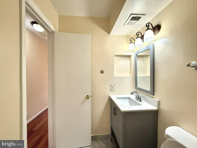 a bathroom with a sink and mirror with shower