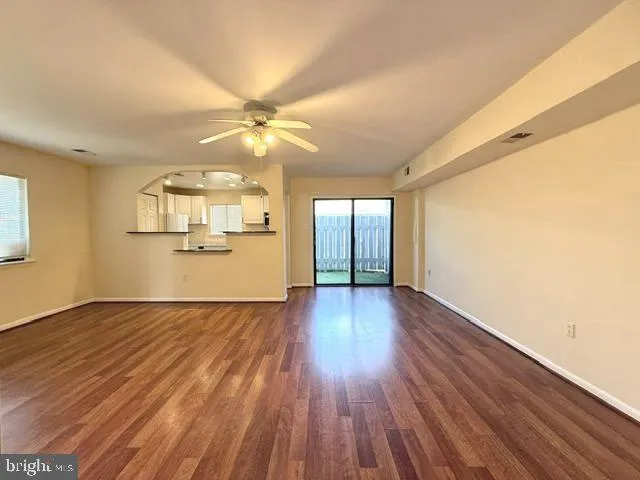 a view of a livingroom with wooden floor and a ceiling fan