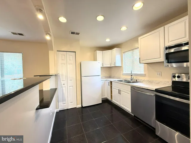 a kitchen with a sink a refrigerator and cabinets