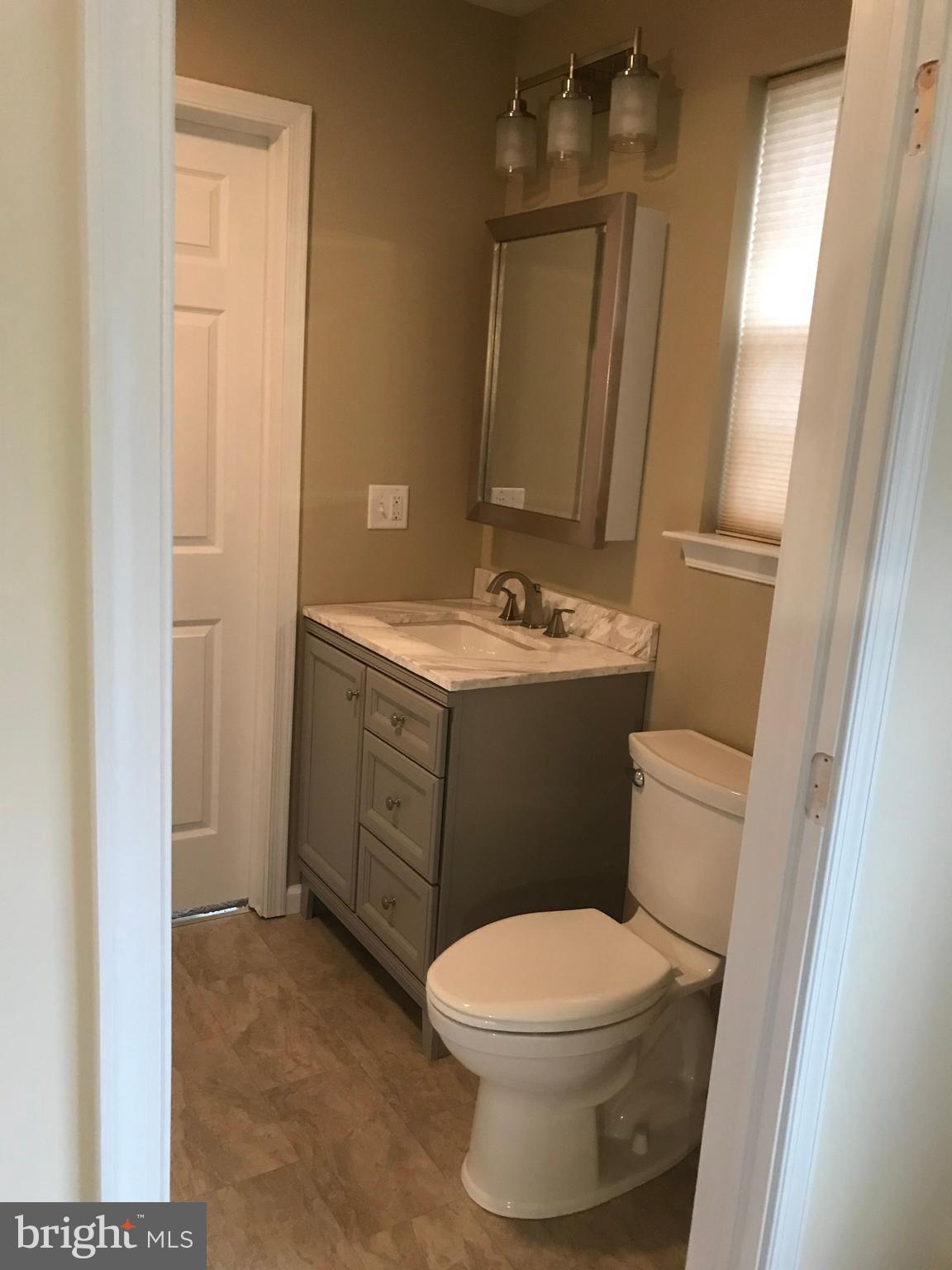 306 Ohio Avenue Wilmington, DE 19805 - Photo 10 of 13 a bathroom with a toilet a sink a vanity and mirror