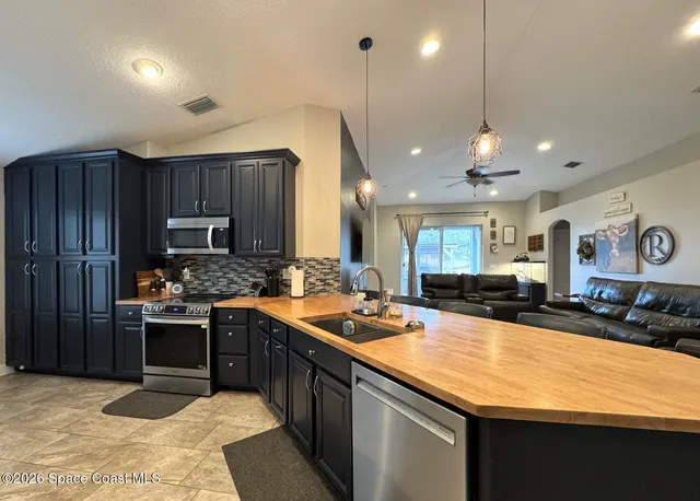 a kitchen with stainless steel appliances granite countertop sink stove and refrigerator