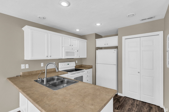 656 South 910 West, Unit 25 Pleasant Grove, UT 84062 - Photo 8 of 25 Modern kitchen featuring white cabinetry, a double basin stainless steel sink, built-in microwave, and a full-size refrigerator.