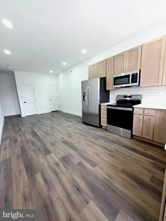 a kitchen with stainless steel appliances a refrigerator and a stove top oven