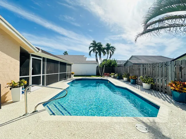 a view of a house with swimming pool and sitting area