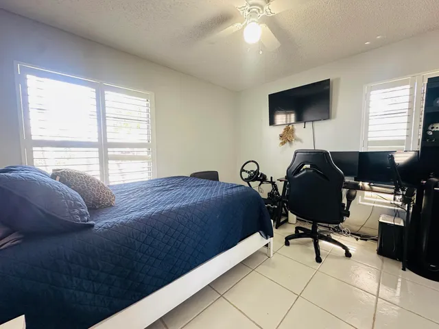 a bedroom with a bed gym equipment and a window