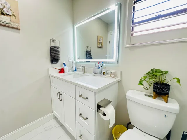 a bathroom with a sink mirror vanity and toilet
