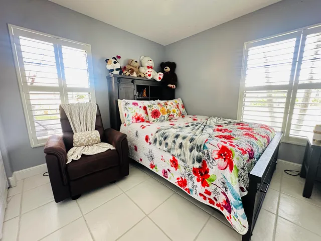 a bedroom with a bed chair and a window