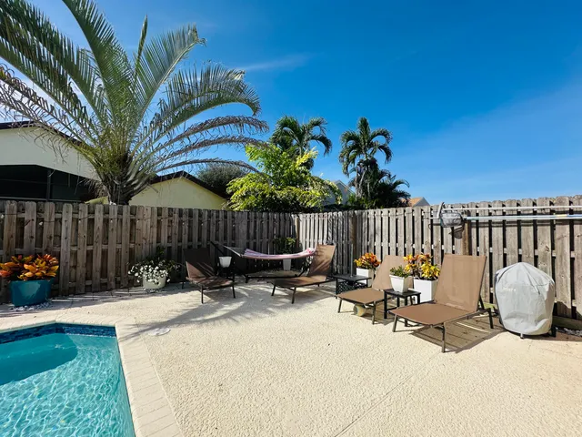 a view of a patio with table and chairs with wooden fence