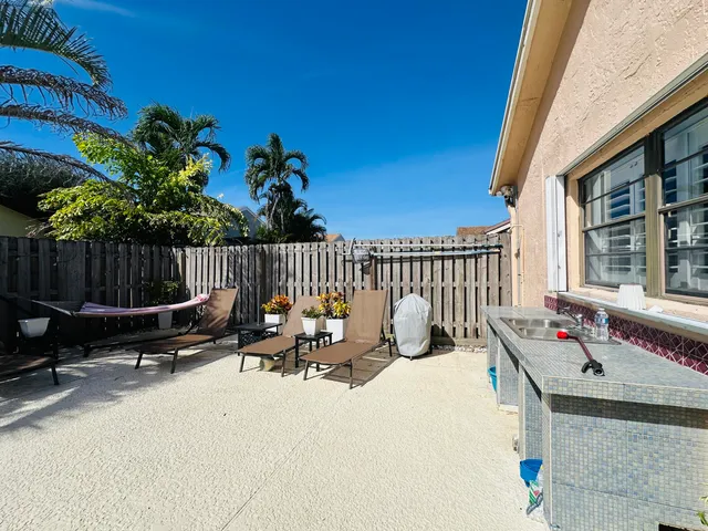 a roof deck with table and chairs and potted plants