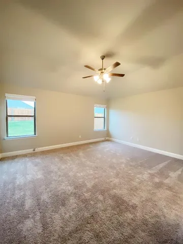 en empty room with windows and ceiling fan view