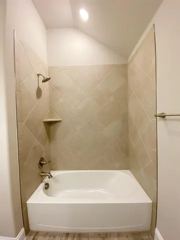 an empty room with a chandelier fan and windows