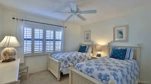 a bedroom with two beds and a window