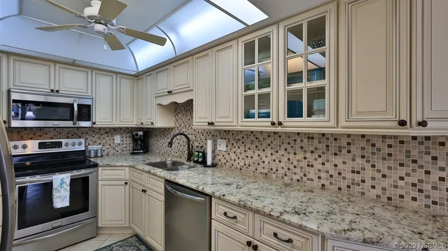 a kitchen with granite countertop a sink a stove and microwave