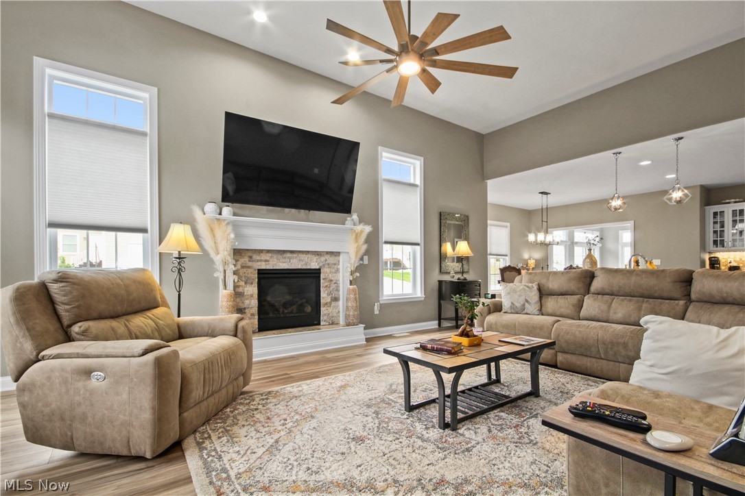 1805 East Western Reserve Road Youngstown, OH 44514 - Photo 21 of 31 Living room with ceiling fan with notable chandelier, hardwood / wood-style flooring, and a stone fireplace