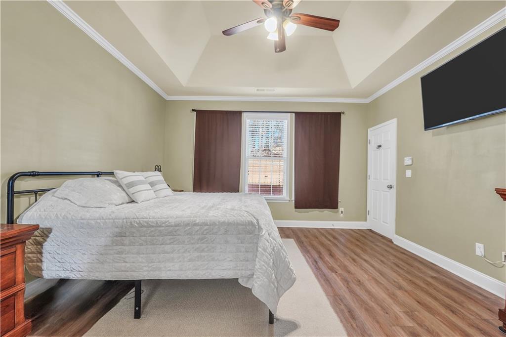 340 Roland Manor Drive Dacula, GA 30019 - Photo 13 of 50 a bedroom with a large bed and a chandelier