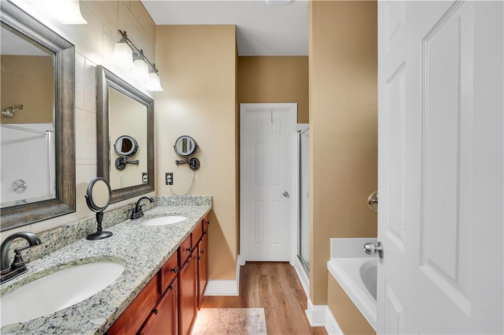 340 Roland Manor Drive Dacula, GA 30019 - Photo 16 of 50 a bathroom with a granite countertop double vanity sink and a mirror