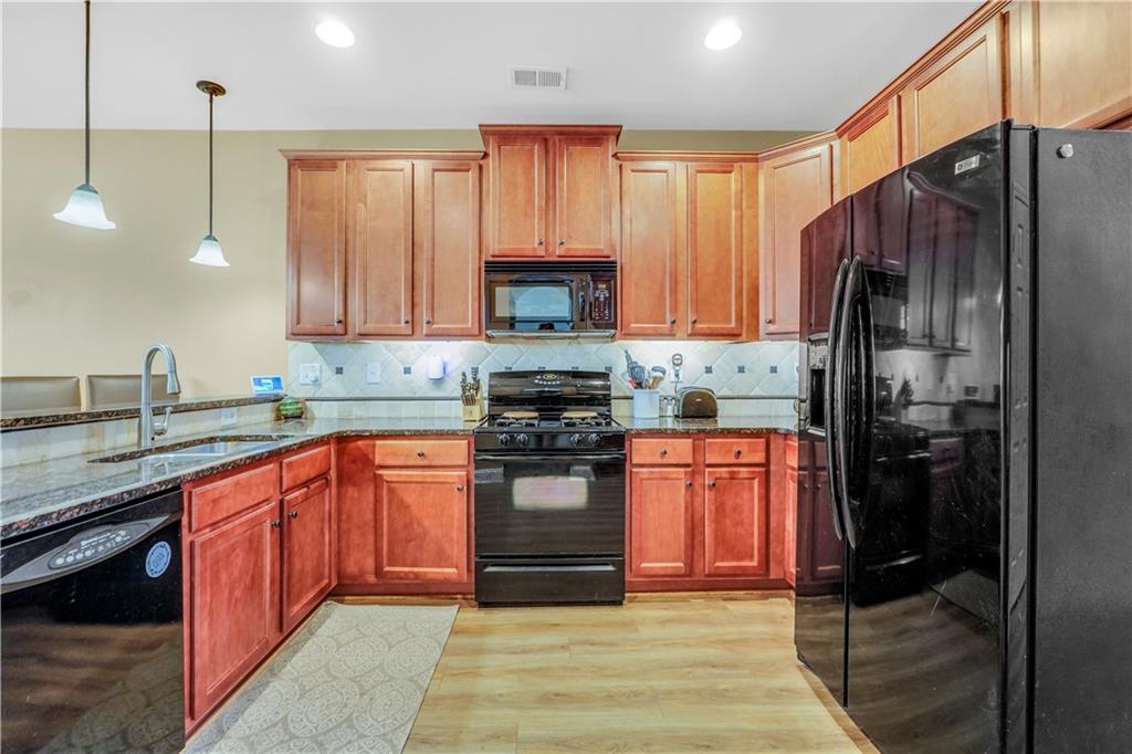 340 Roland Manor Drive Dacula, GA 30019 - Photo 27 of 50 a kitchen with stainless steel appliances granite countertop a stove a refrigerator and a sink