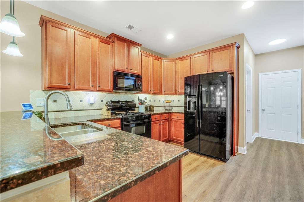 340 Roland Manor Drive Dacula, GA 30019 - Photo 28 of 50 a kitchen with stainless steel appliances granite countertop a refrigerator stove top oven and sink