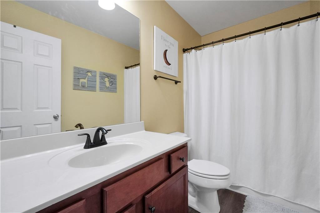 340 Roland Manor Drive Dacula, GA 30019 - Photo 38 of 50 a bathroom with a sink a toilet and shower curtain