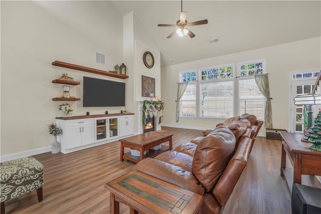 340 Roland Manor Drive Dacula, GA 30019 - Photo 4 of 50 a living room with furniture a flat screen tv and wooden floor