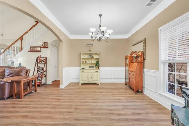 an entryway with wooden floor and a bathroom