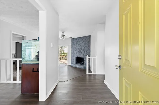 a view of a hallway with wooden floor and a living room