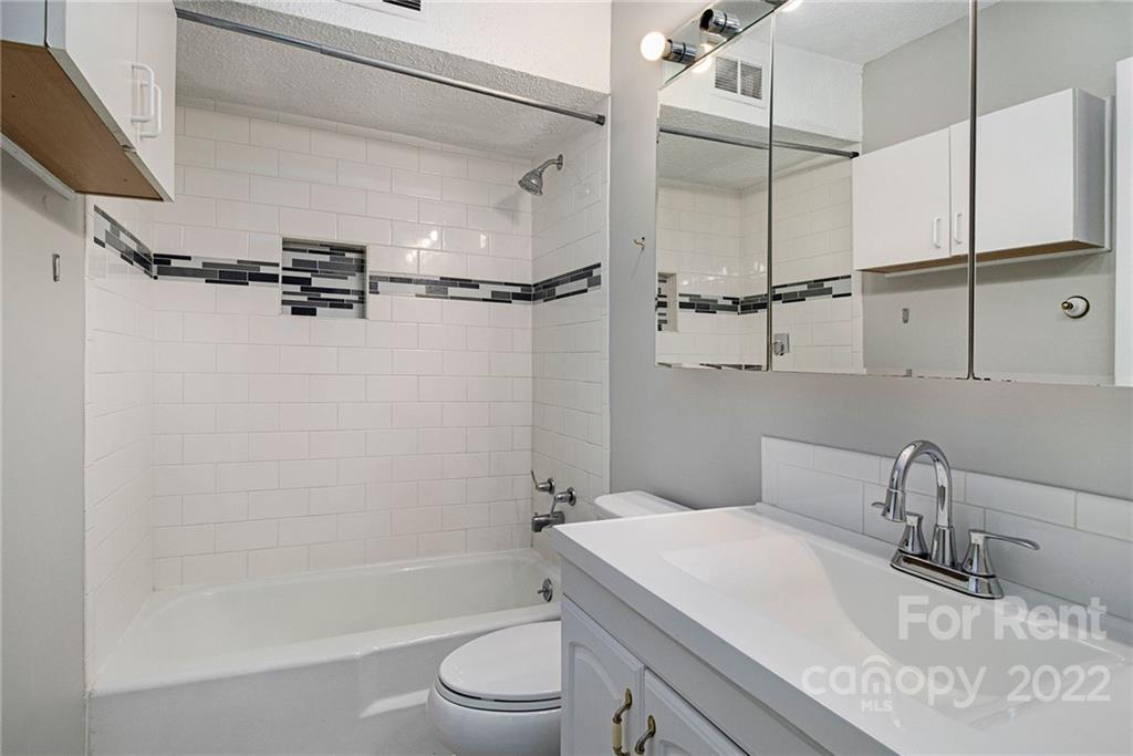 2624 Park Road, Unit E Charlotte, NC 28209 - Photo 14 of 26 a bathroom with a granite countertop sink toilet and shower