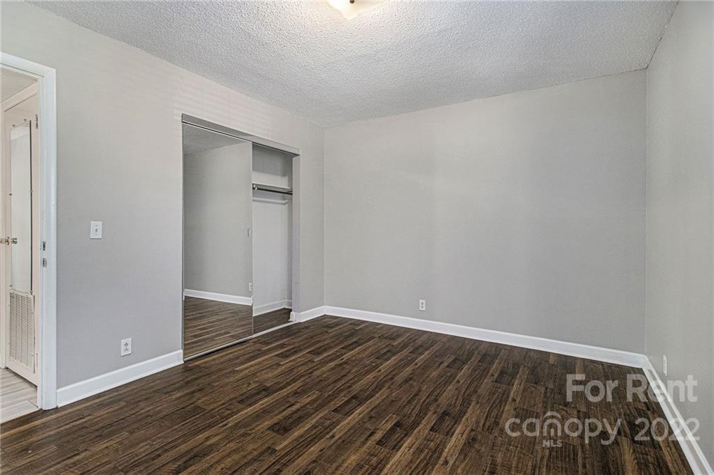2624 Park Road, Unit E Charlotte, NC 28209 - Photo 16 of 26 a view of an empty room with wooden floor and a window