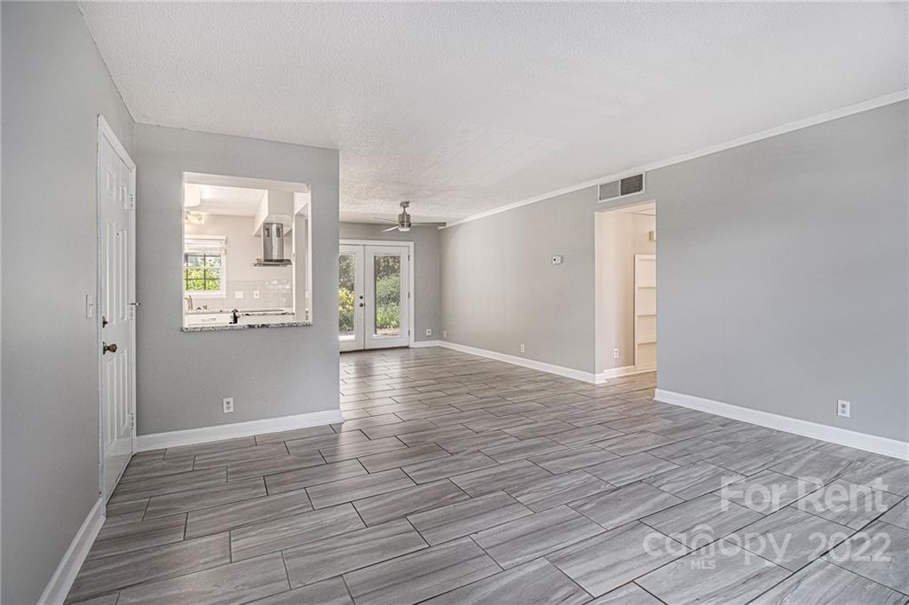 2624 Park Road, Unit E Charlotte, NC 28209 - Photo 3 of 26 a view of an empty room with wooden floor and a window