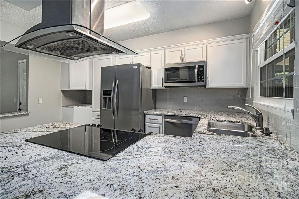 2624 Park Road, Unit E Charlotte, NC 28209 - Photo 8 of 26 a kitchen with stainless steel appliances granite countertop a sink a microwave a stove and refrigerator