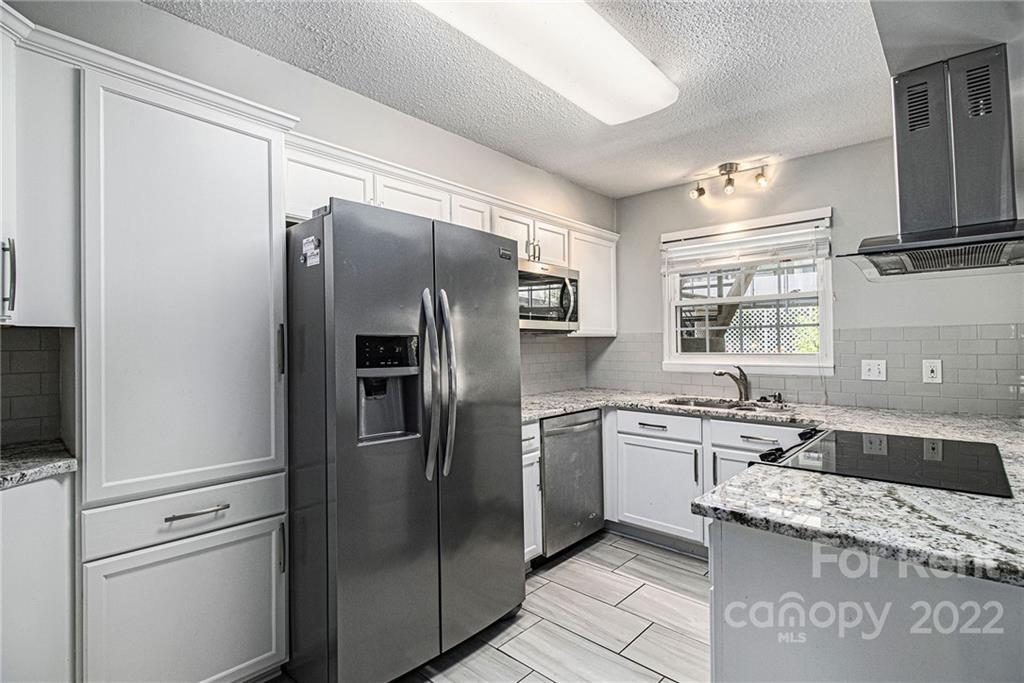2624 Park Road, Unit E Charlotte, NC 28209 - Photo 9 of 26 a kitchen with stainless steel appliances granite countertop a refrigerator and a sink