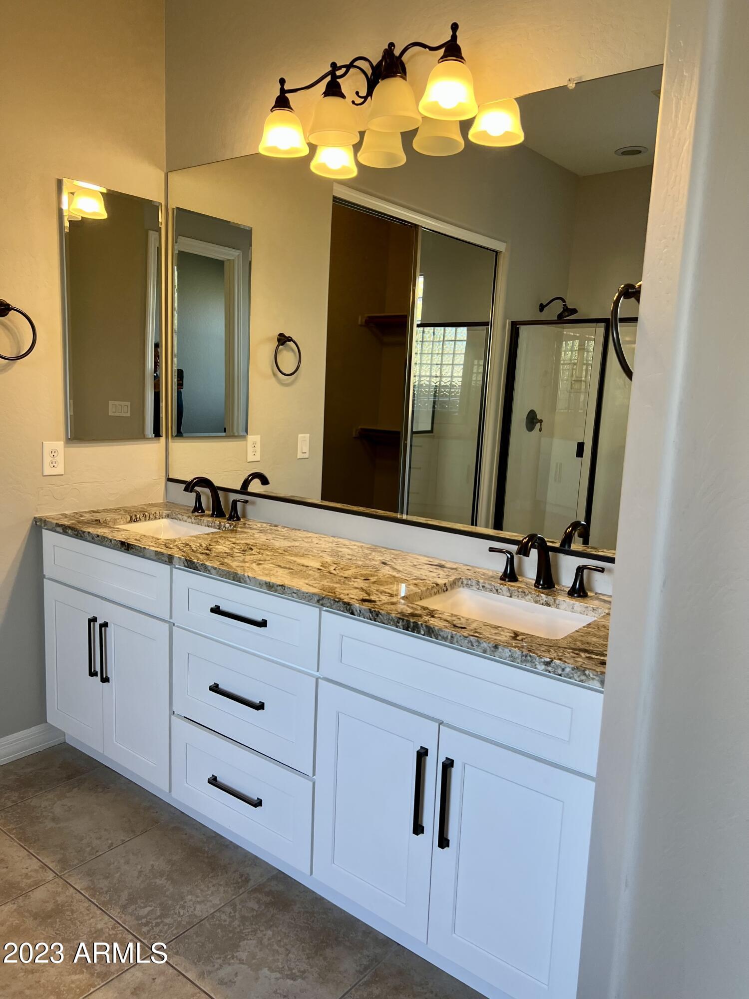 20296 East Sonoqui Boulevard Queen Creek, AZ 85142 - Photo 17 of 22 a bathroom with a double vanity sink and a mirror