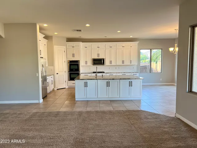a large kitchen with cabinets and wooden floor