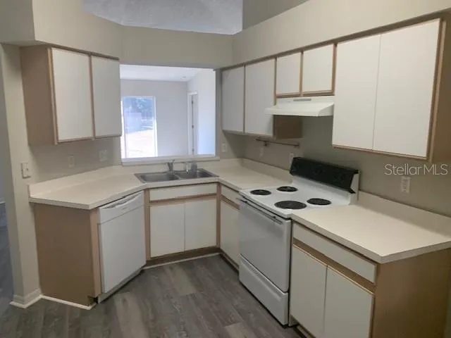 a kitchen with a sink stove top oven and cabinets